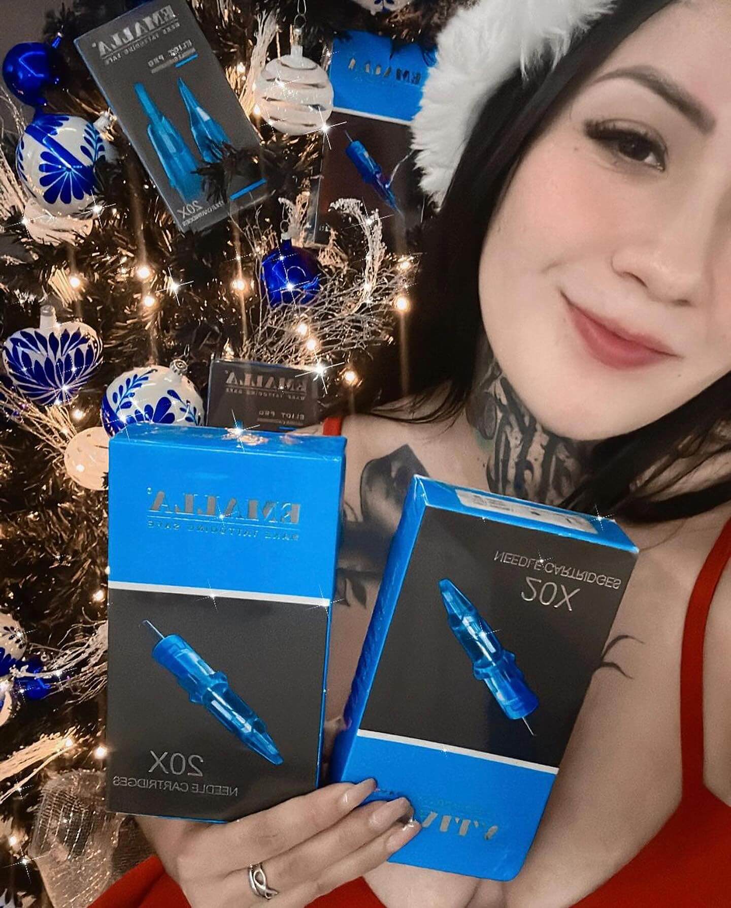 In a festive Christmas atmosphere, a female tattoo artist presents her Emalla cartridge needles.