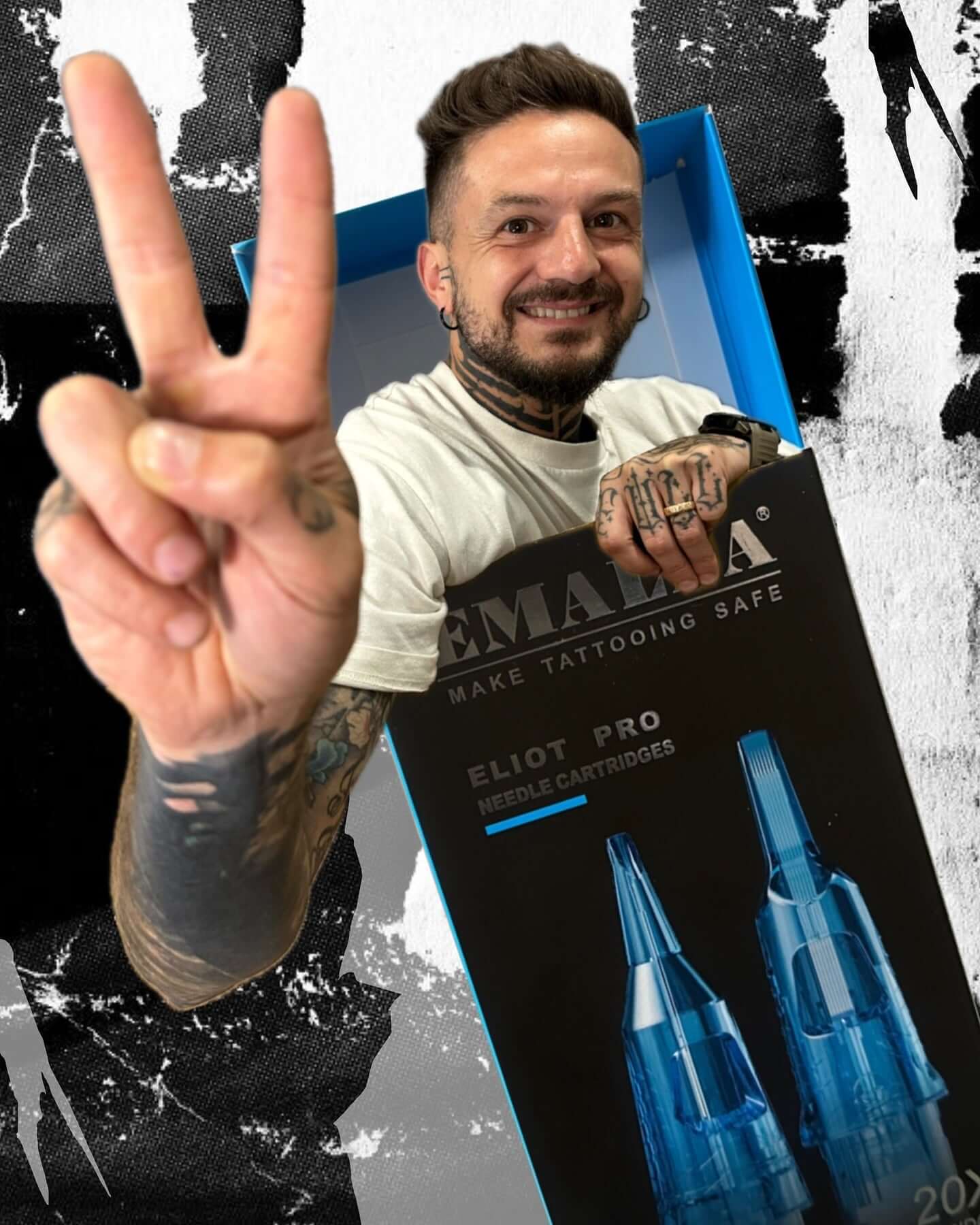 Master Andrea Zorloni playfully poses with an oversized box of Emalla Eliot Pro cartridges, smiling and giving a victory sign.